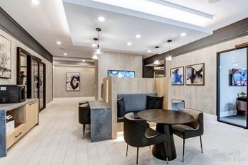 A modern living room with a grey sofa, a round table and a television at Mayla Pompano, Pompano Beach, FL